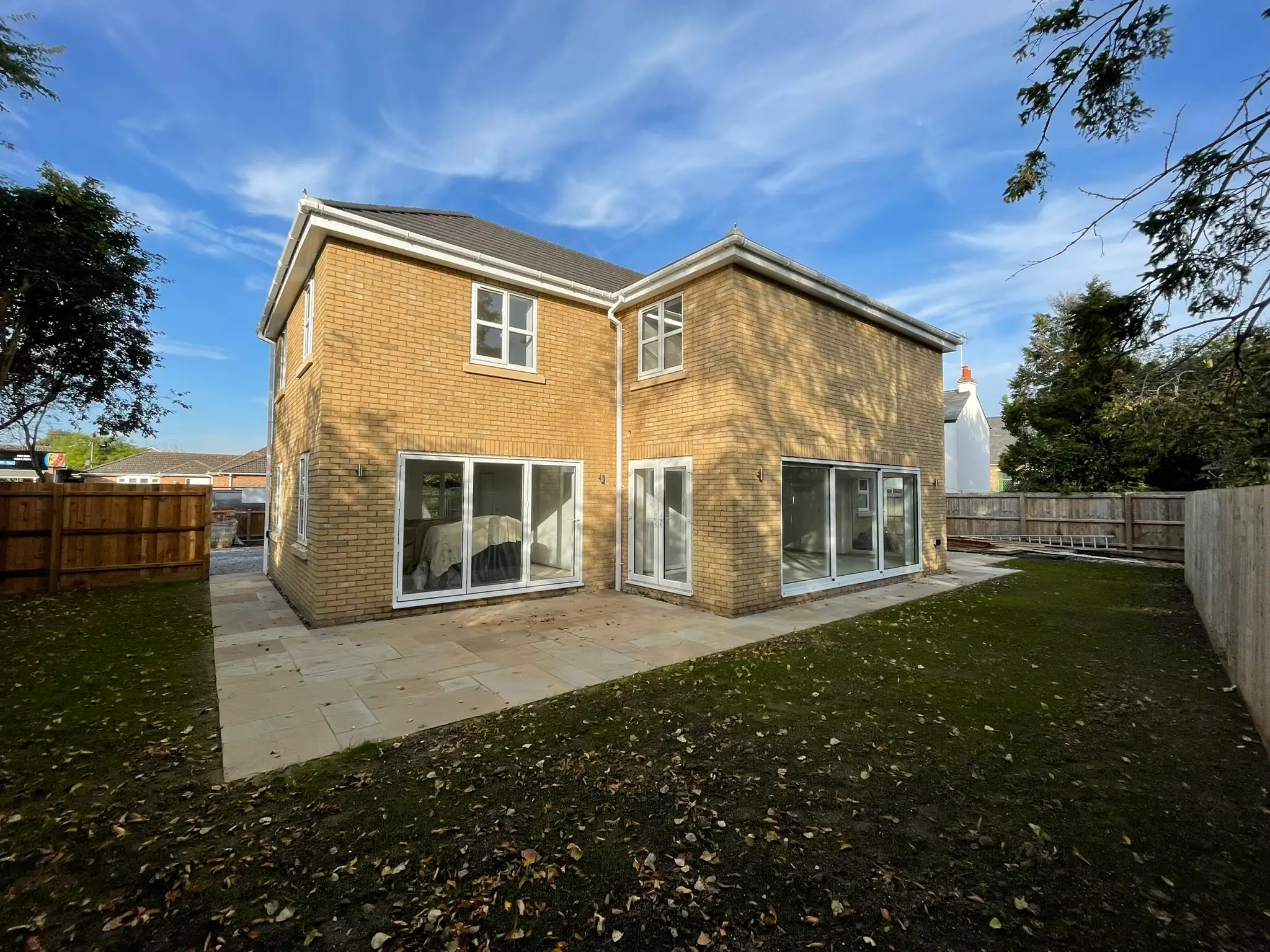 Sandstone patio and lawn behind a new build